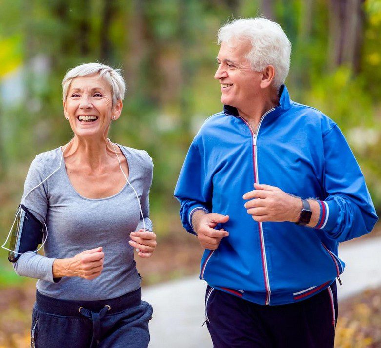 Couple de seniors courant en forêt